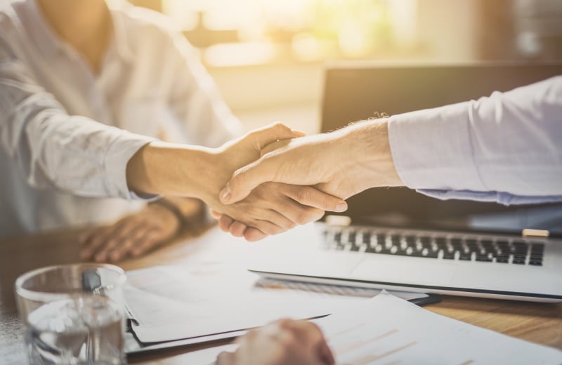 協力、パートナーシップ、ビジネス取引を象徴する二人の握手の様子